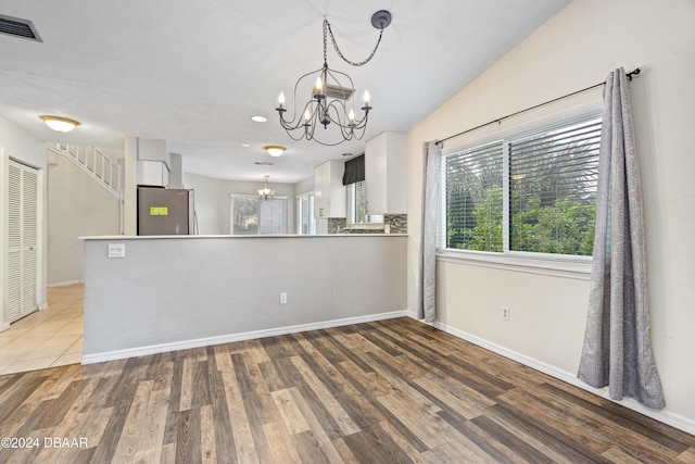 interior space featuring light wood-type flooring and an inviting chandelier