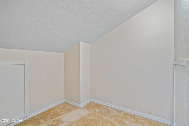 carpeted spare room with lofted ceiling