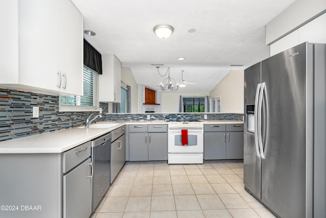 kitchen featuring gray cabinetry, pendant lighting, lofted ceiling, and appliances with stainless steel finishes