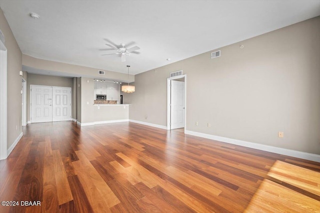 unfurnished living room featuring hardwood / wood-style flooring and ceiling fan