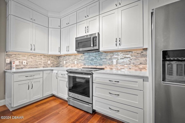 kitchen with light wood-type flooring, white cabinetry, appliances with stainless steel finishes, and tasteful backsplash