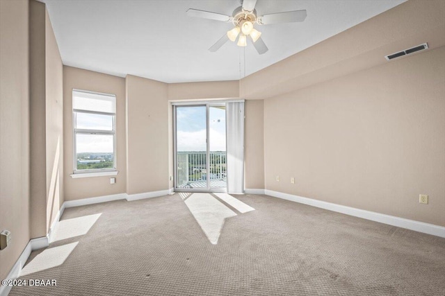 carpeted spare room with ceiling fan and a healthy amount of sunlight