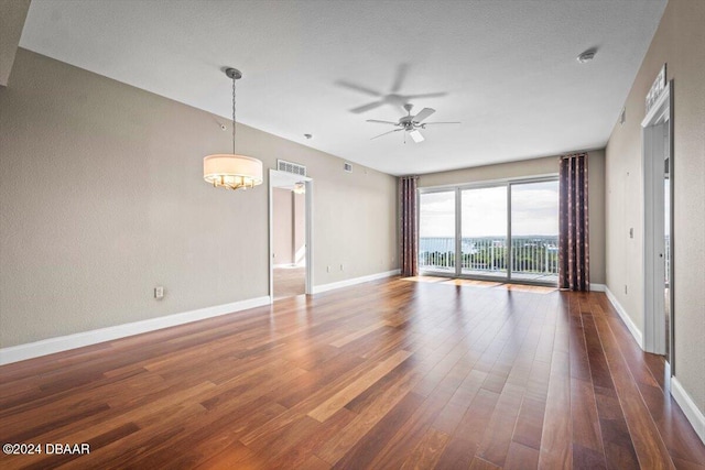 unfurnished room with dark hardwood / wood-style flooring and ceiling fan