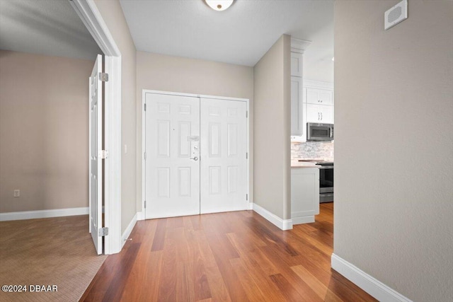 corridor with hardwood / wood-style flooring