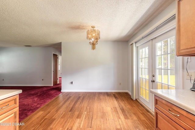 5060 Audubon Ave, Deleon Springs, FL 32130 - unfurnished dining area featuring light wood-type flooring, a textured ceiling, and a chandelier