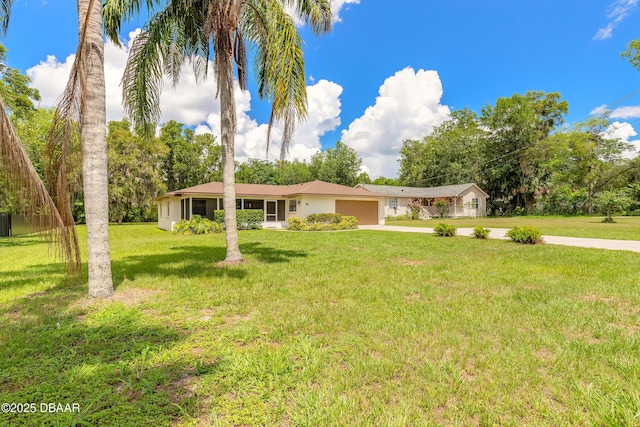 5060 Audubon Ave, Deleon Springs, FL 32130 - single story home with a garage, driveway, a front lawn, and stucco siding