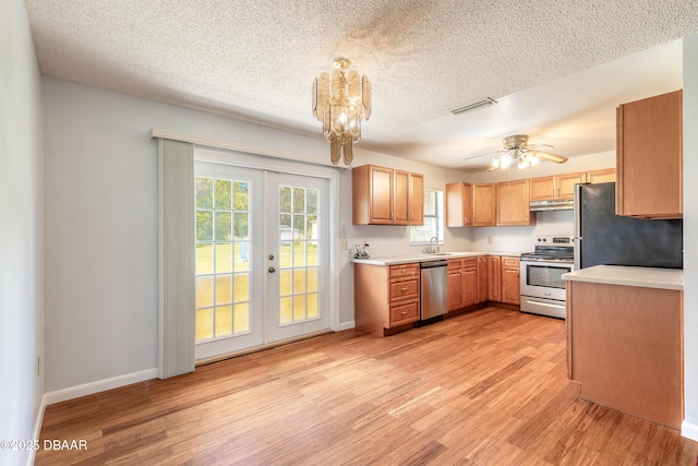 5060 Audubon Ave, Deleon Springs, FL 32130 - kitchen with stainless steel appliances, french doors, light wood-type flooring, light countertops, and a textured ceiling