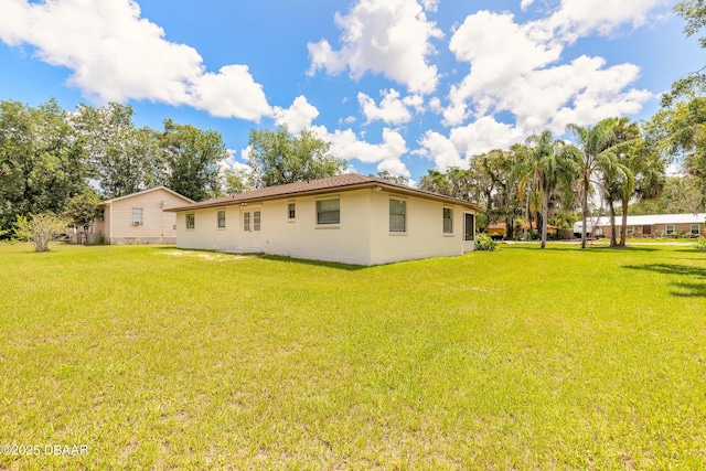 5060 Audubon Ave, Deleon Springs, FL 32130 - back of house featuring a lawn and stucco siding