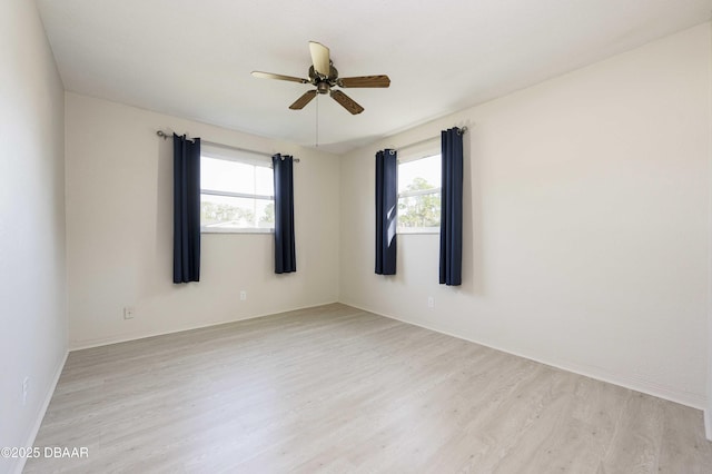 empty room with ceiling fan and light hardwood / wood-style floors