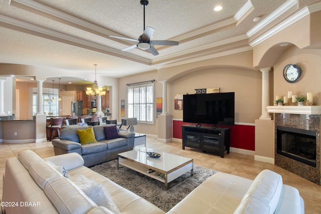 living room featuring crown molding, a high end fireplace, a healthy amount of sunlight, and ceiling fan with notable chandelier