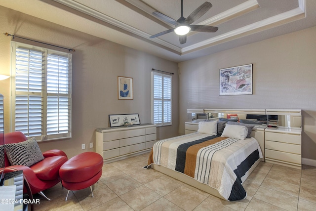 bedroom with light tile patterned floors, a tray ceiling, and ceiling fan