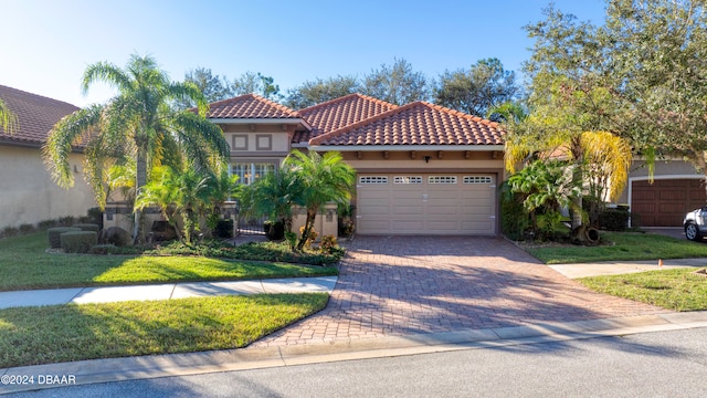 mediterranean / spanish home with a front lawn and a garage