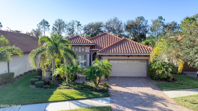 mediterranean / spanish-style house with a front yard and a garage