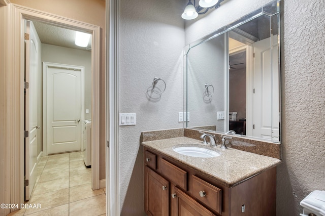 bathroom with tile patterned flooring, vanity, and a textured ceiling