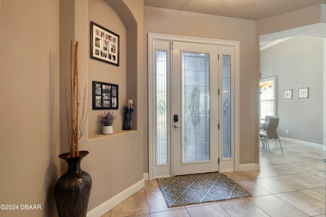 tiled entryway with a textured ceiling