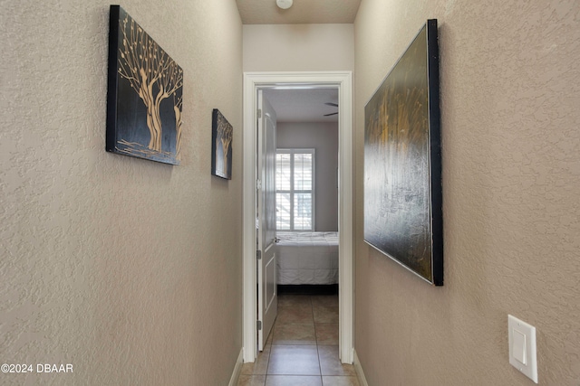 hall with tile patterned floors