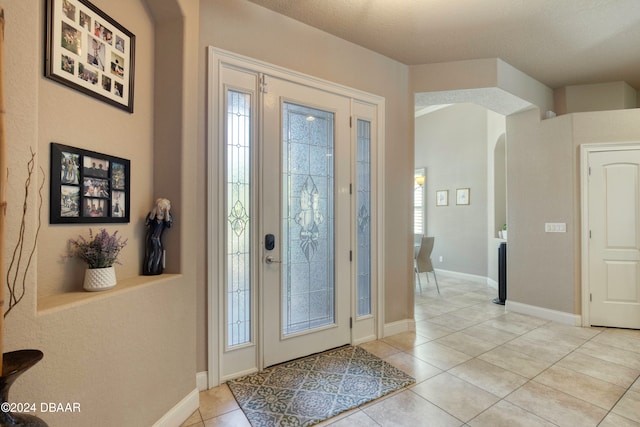 entrance foyer featuring a textured ceiling and light tile patterned flooring