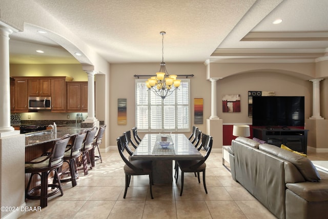 tiled dining space featuring ornamental molding, a textured ceiling, and a chandelier