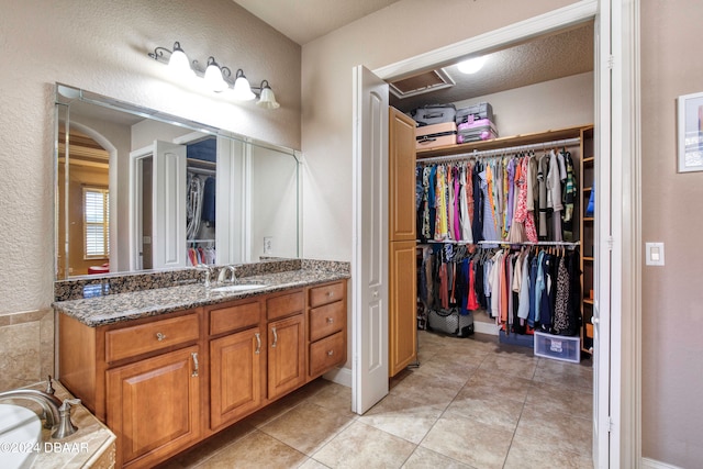 bathroom featuring tile patterned flooring, a textured ceiling, and vanity