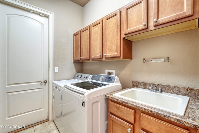 washroom with light tile patterned flooring, cabinets, separate washer and dryer, and sink