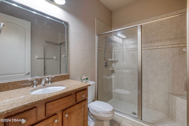 bathroom with vanity, an enclosed shower, and toilet