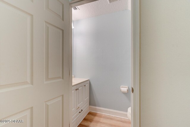 209 Tarracina Way, Daytona Beach, FL 32117 - bathroom with vanity, toilet, a textured ceiling, baseboards, and wood finished floors