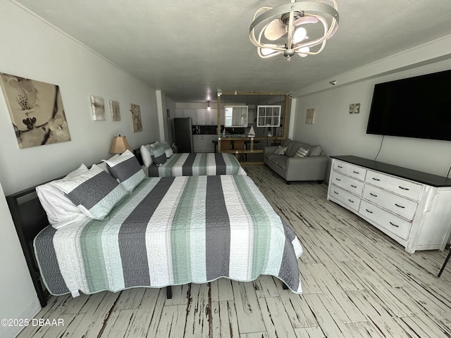 1909 S Atlantic Ave Unit 213, Daytona Beach, FL 32118 - bedroom with light wood-style flooring, a chandelier, and freestanding refrigerator