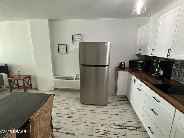 1909 S Atlantic Ave Unit 213, Daytona Beach, FL 32118 - kitchen with appliances with stainless steel finishes, butcher block counters, tasteful backsplash, white cabinets, and light marble finish floors