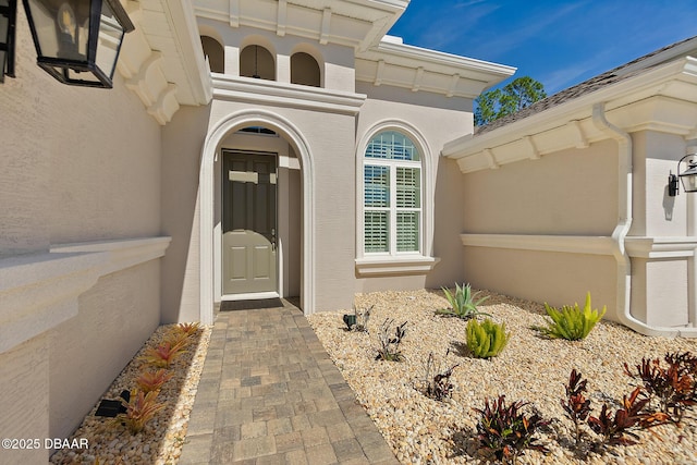 doorway to property featuring stucco siding