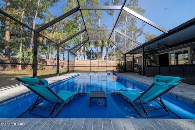 view of pool with glass enclosure, a patio area, a fenced backyard, and a fenced in pool