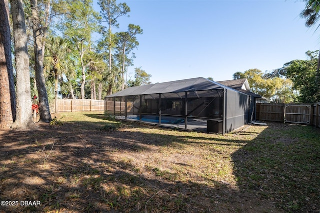 view of yard with a lanai, a fenced backyard, and a fenced in pool