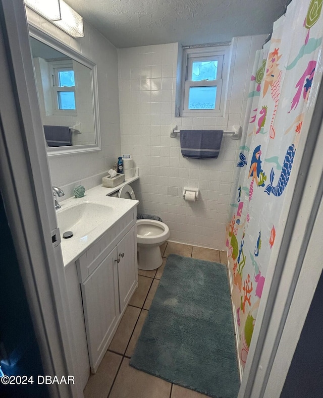 bathroom with toilet, tile walls, tile patterned flooring, a textured ceiling, and vanity