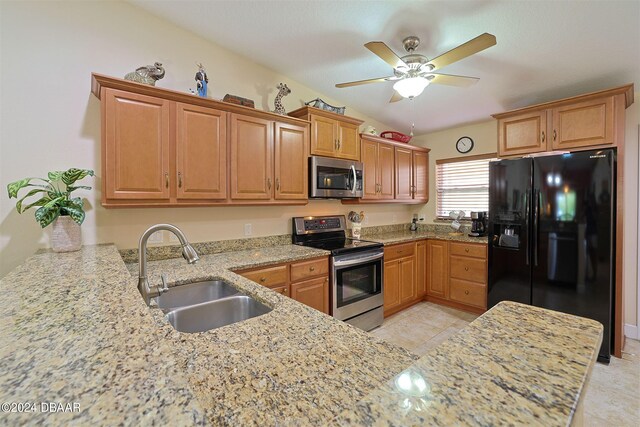 kitchen with sink, kitchen peninsula, ceiling fan, light stone countertops, and stainless steel appliances