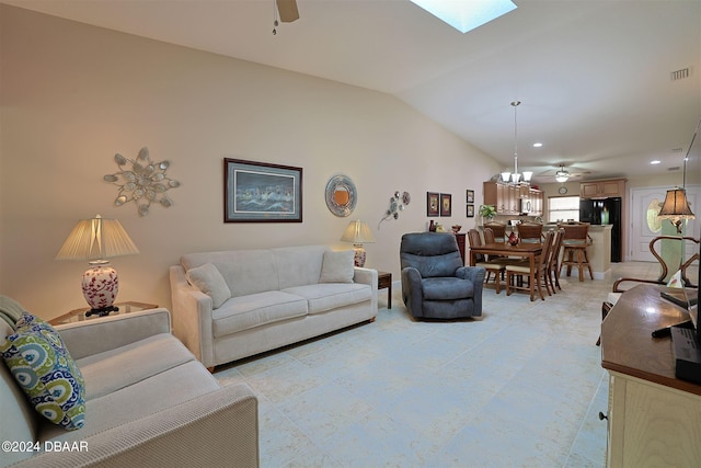 living room with ceiling fan with notable chandelier and lofted ceiling with skylight