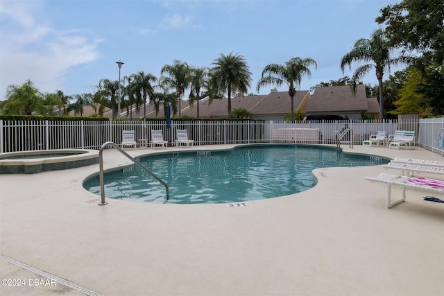 view of swimming pool with a community hot tub and a patio area