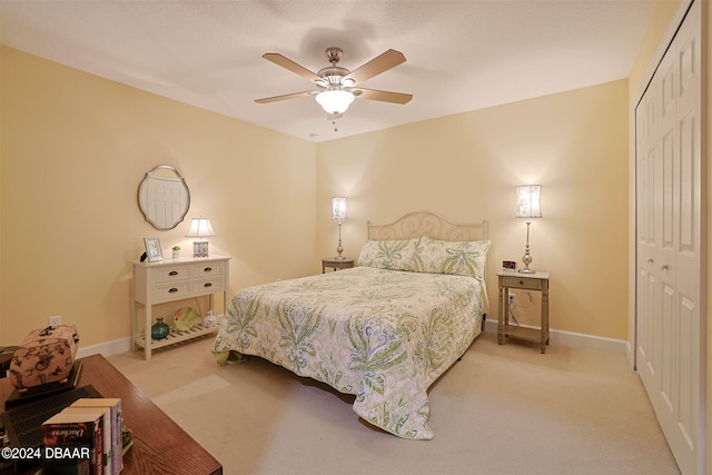 bedroom featuring ceiling fan, a closet, and light colored carpet