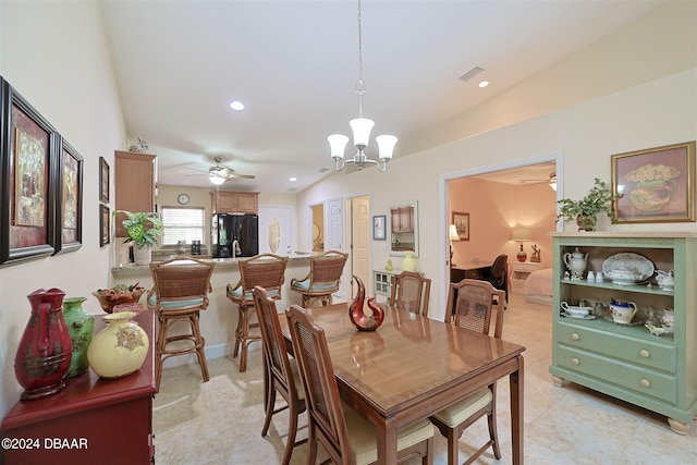 dining area with ceiling fan with notable chandelier, light tile patterned flooring, and lofted ceiling