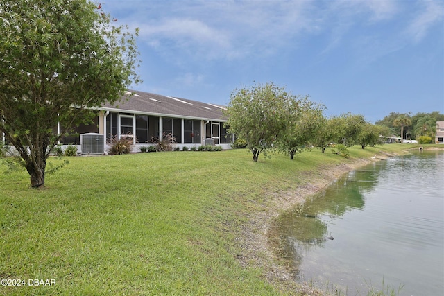 view of yard featuring a water view, central AC unit, and a sunroom