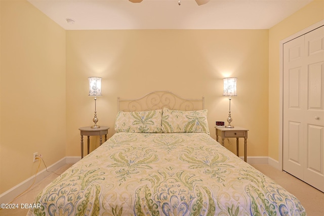 bedroom featuring ceiling fan, a closet, and light colored carpet