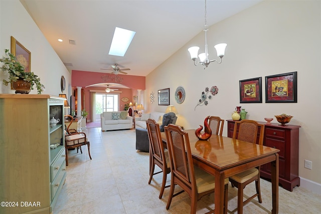 dining area featuring a skylight, high vaulted ceiling, and ceiling fan with notable chandelier