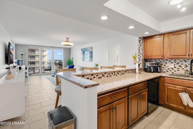 2947 S Atlantic Ave Unit 601, Daytona Beach, FL 32118 - kitchen featuring backsplash, light tile patterned floors, light stone countertops, a peninsula, and recessed lighting