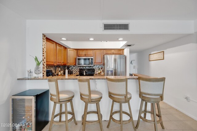 2947 S Atlantic Ave Unit 601, Daytona Beach, FL 32118 - kitchen featuring appliances with stainless steel finishes, tasteful backsplash, a peninsula, light stone countertops, and recessed lighting