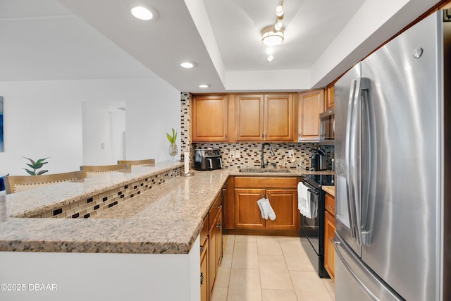 2947 S Atlantic Ave Unit 601, Daytona Beach, FL 32118 - kitchen featuring appliances with stainless steel finishes, a peninsula, light stone countertops, backsplash, and light tile patterned floors