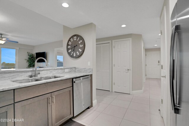 3721 S Atlantic Ave Unit 207, Daytona Beach Shores, FL 32118 - kitchen with stainless steel dishwasher, freestanding refrigerator, light tile patterned floors, light stone countertops, and ceiling fan