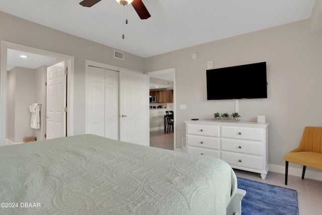 tiled bedroom featuring ceiling fan and a closet