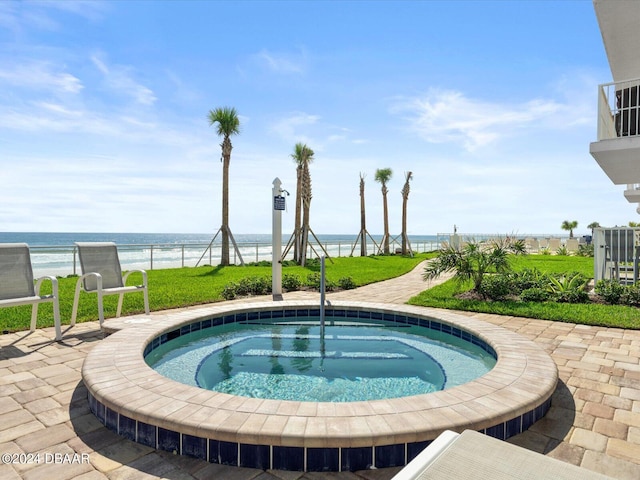 view of pool with a patio, an in ground hot tub, and a water view