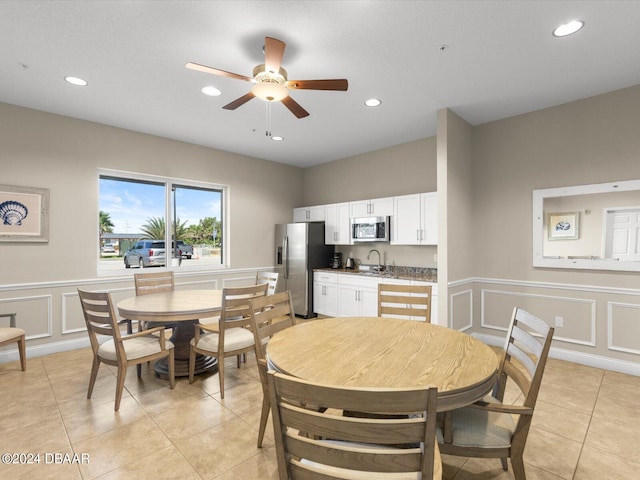 tiled dining space with sink and ceiling fan