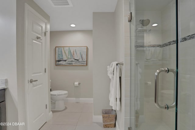 bathroom featuring vanity, a shower with shower door, tile patterned floors, and toilet