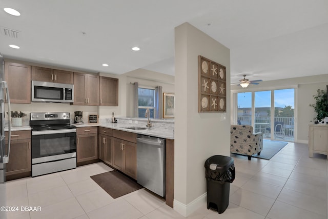 kitchen featuring stainless steel appliances, light tile patterned floors, ceiling fan, and sink