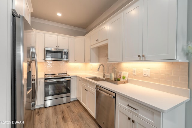 kitchen with white cabinets, appliances with stainless steel finishes, decorative backsplash, and sink